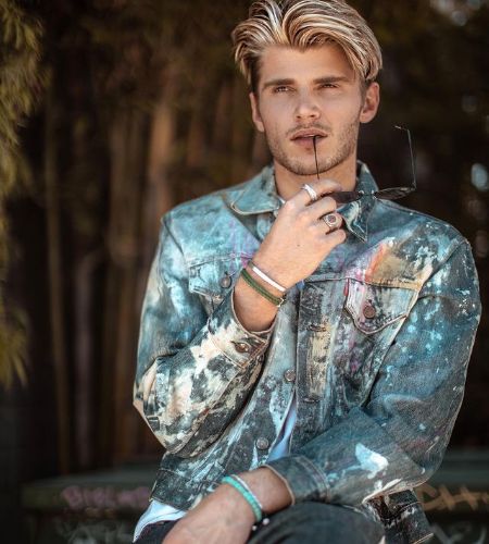 Picture Twan kuyper doing photoshoot with sunglass in his hand.